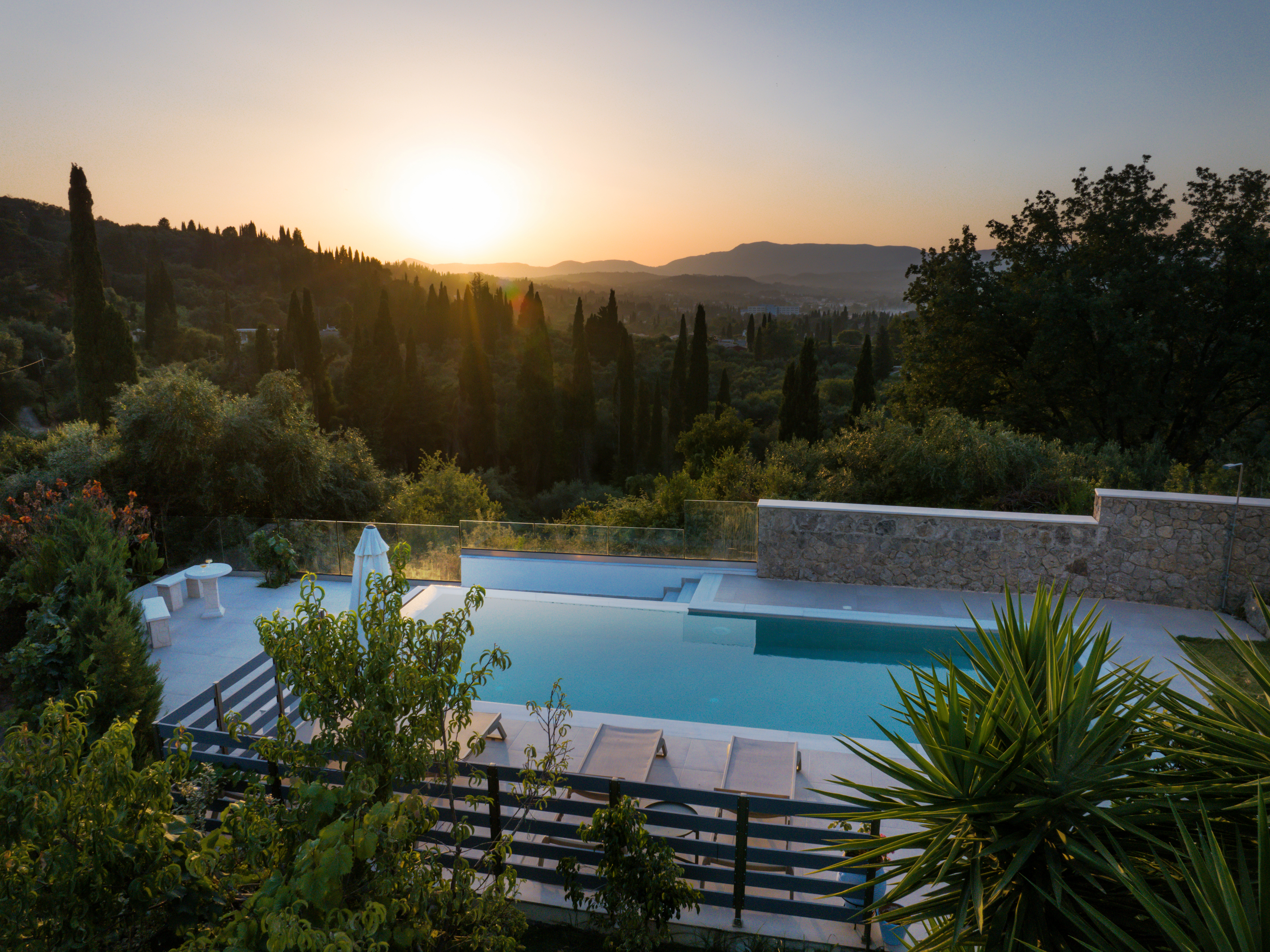 Drone aerial view of luxury villa and infinity pool overlooking the Corfu coastline