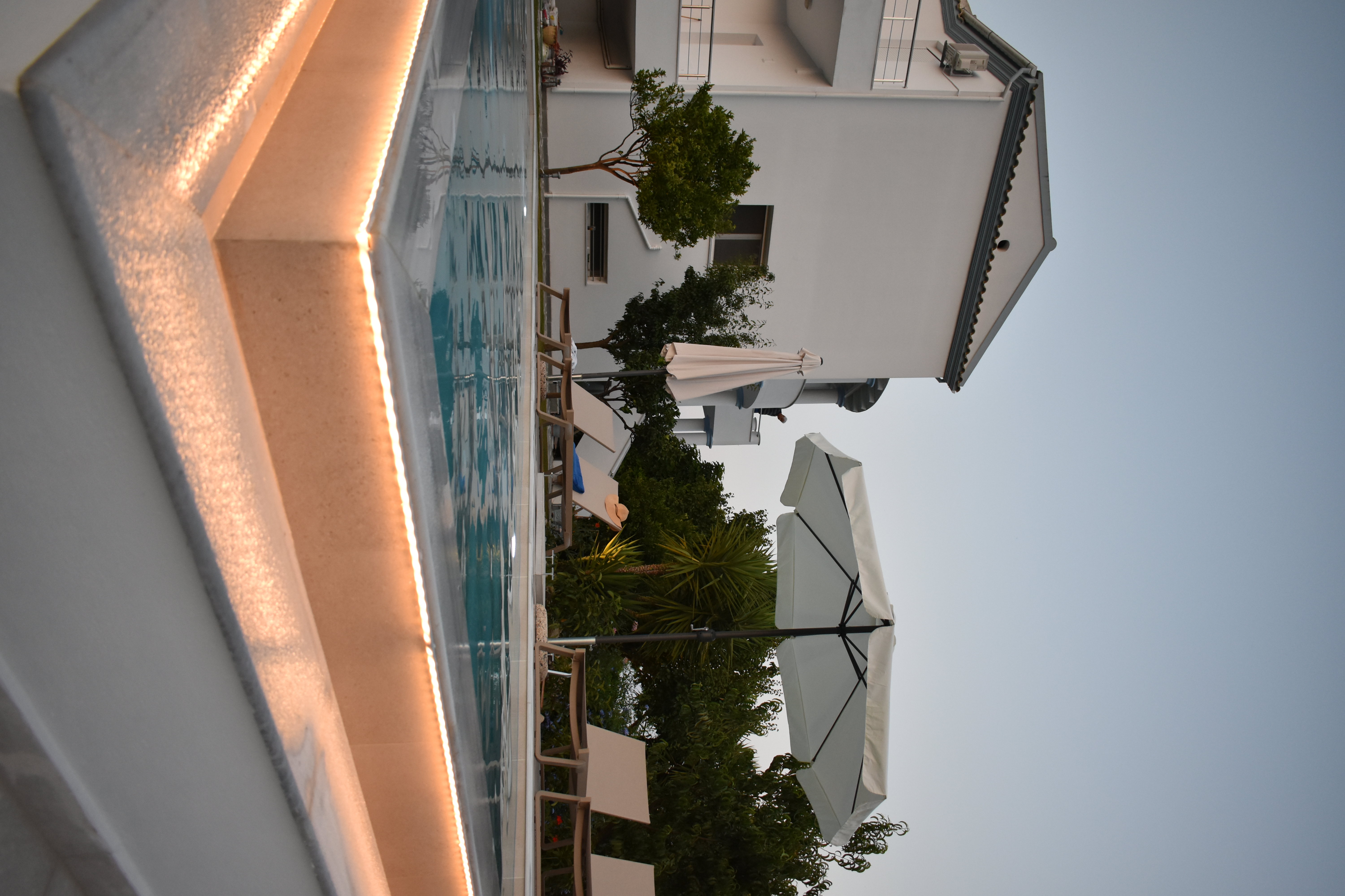 Infinity pool at night with ambient lights and sea view in Corfu