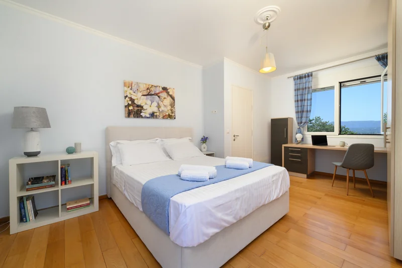 Guest bedroom with large windows at Olga’s Luxury Villa